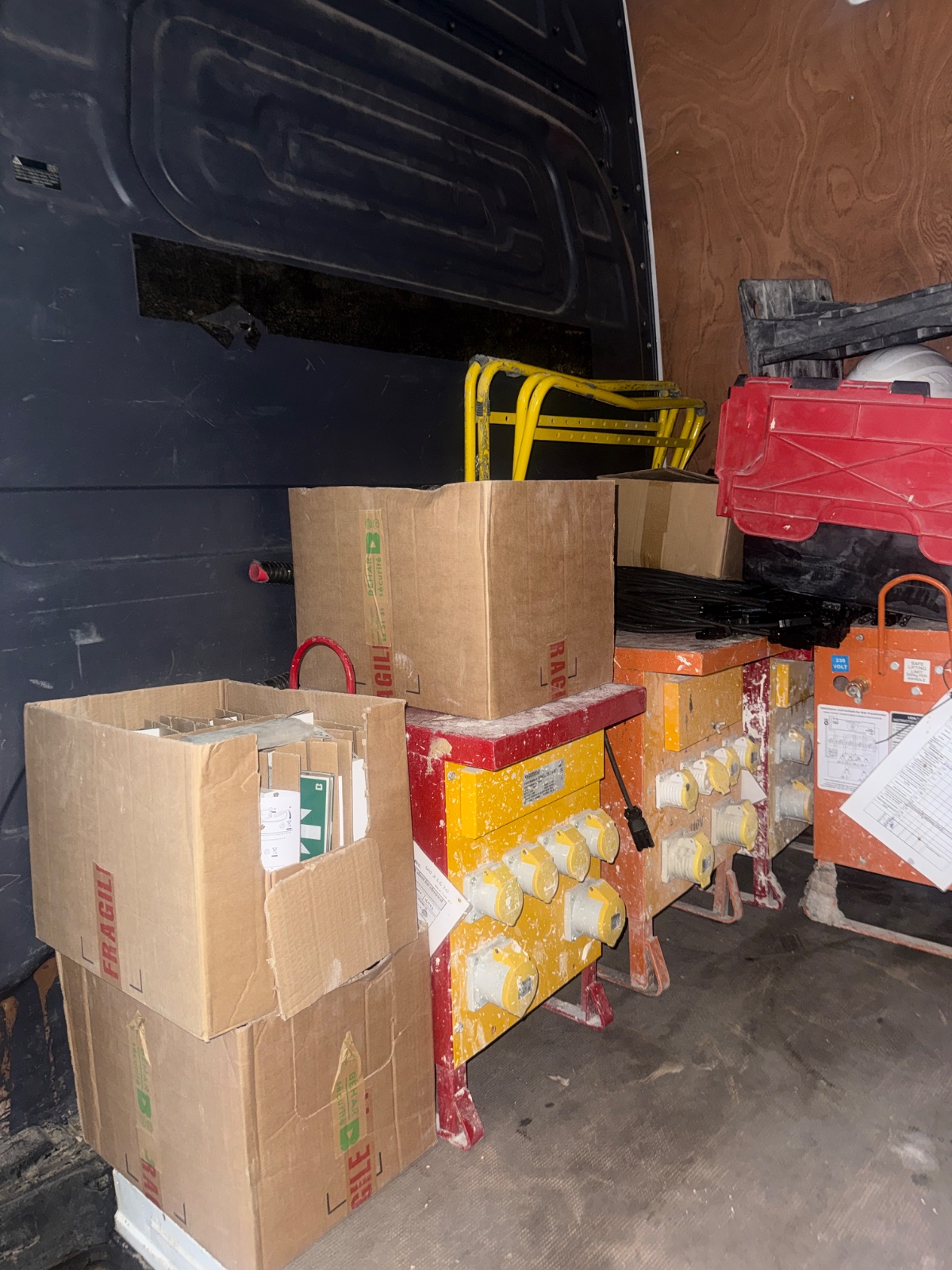 Cardboard boxes and electrical distribution units inside a van — job TE-149MD082026